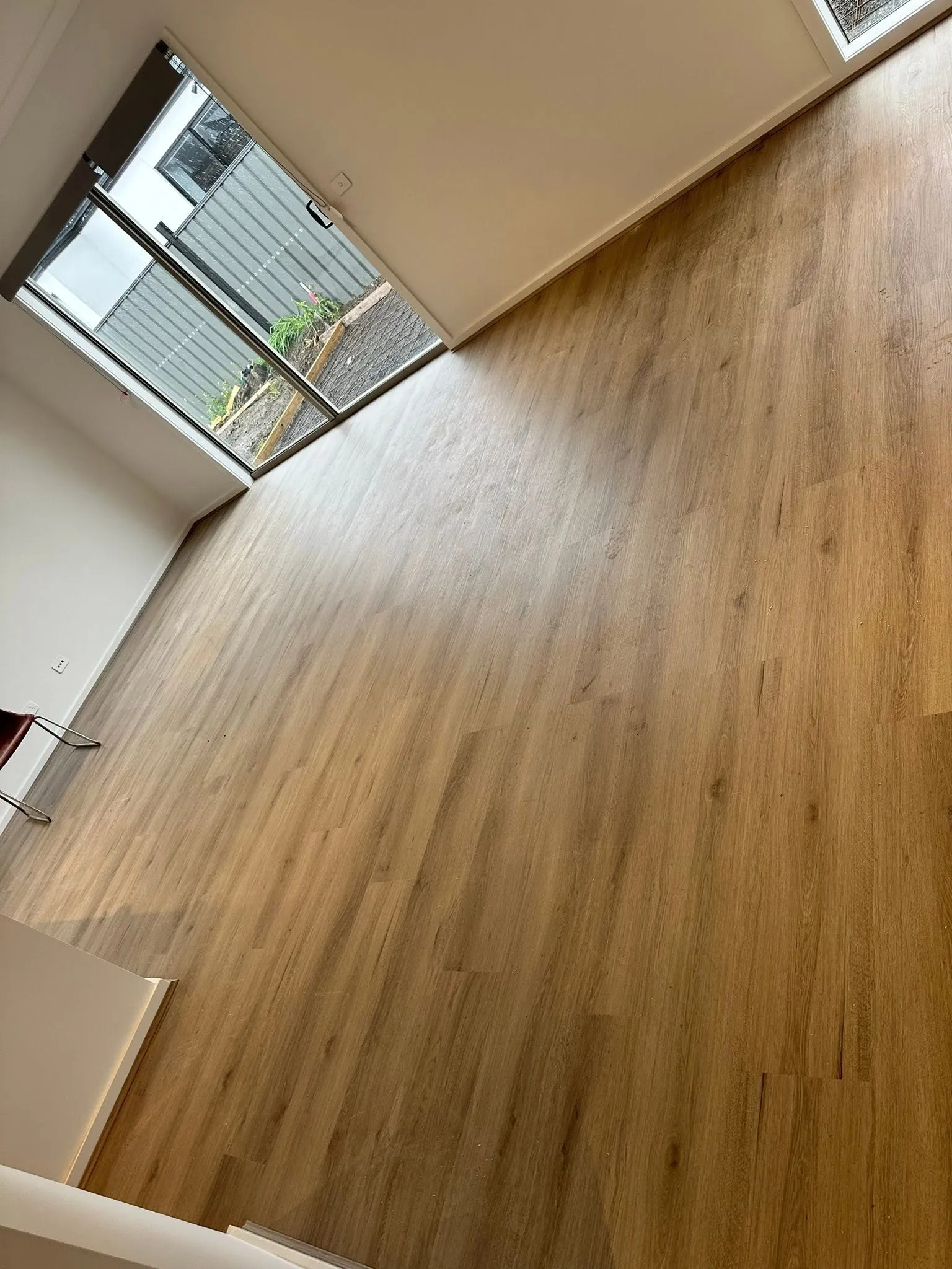 Tan Oak hybrid flooring across a living area with a large glass door