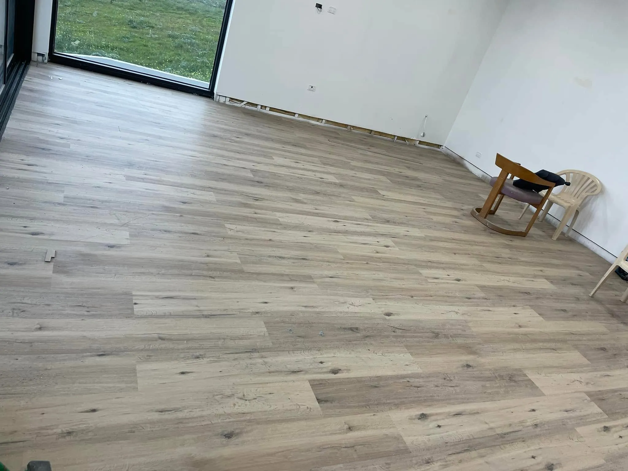 Light timber-look flooring in an apartment room with a large window