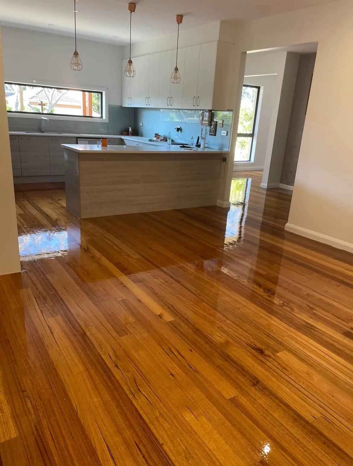 High-gloss timber flooring in an open-plan kitchen