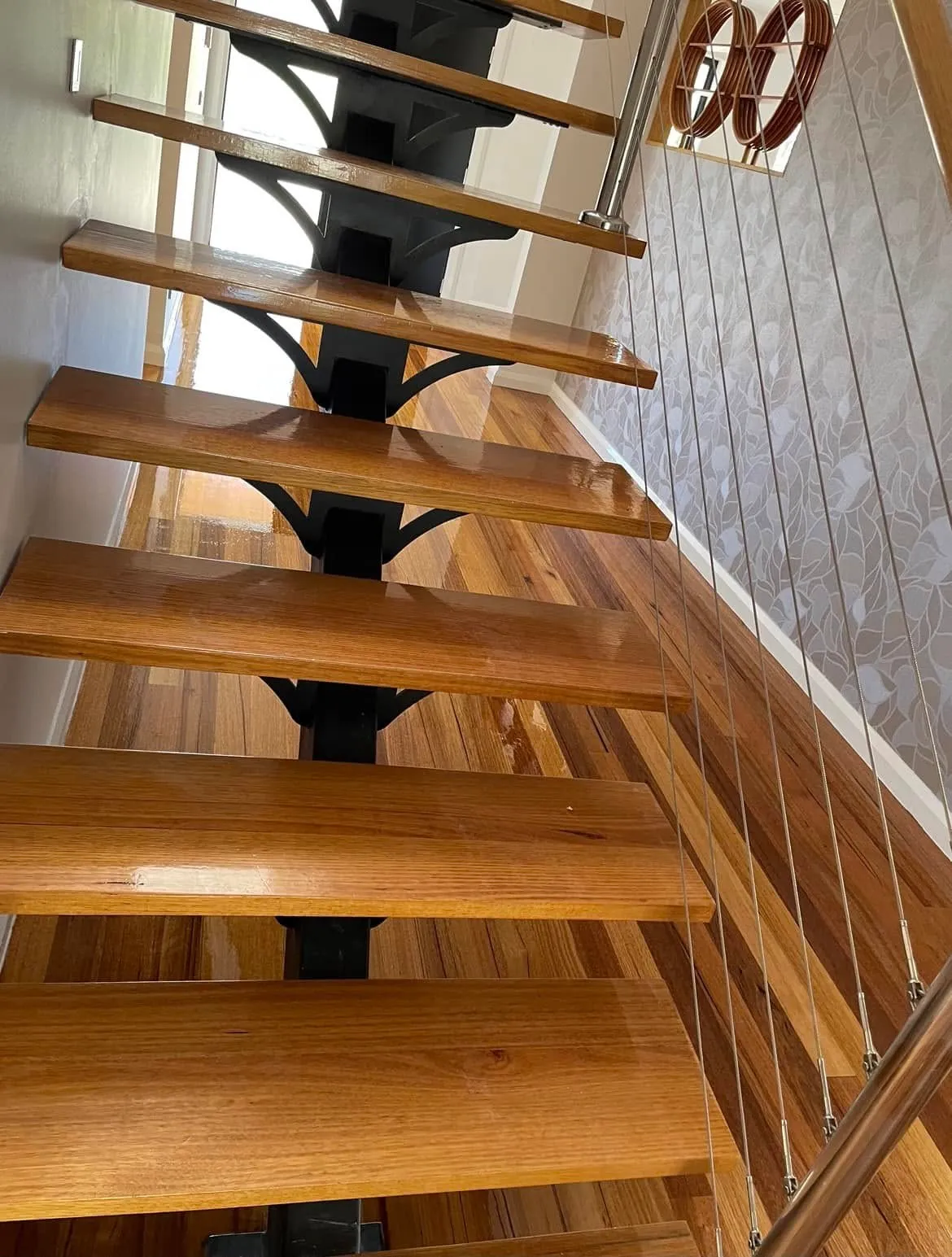 High-gloss timber staircase treads matching the floor below