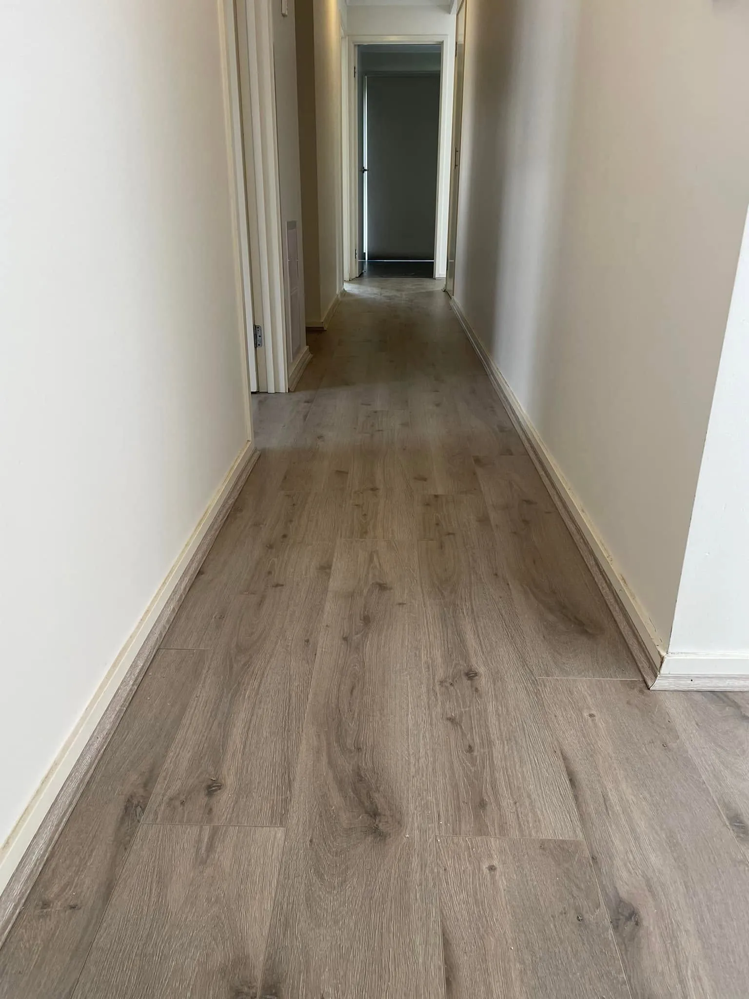 Light grey flooring running down a hallway