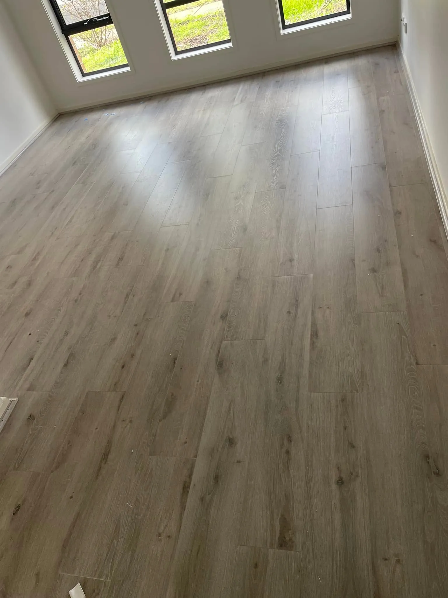 Light grey flooring in a room with large windows